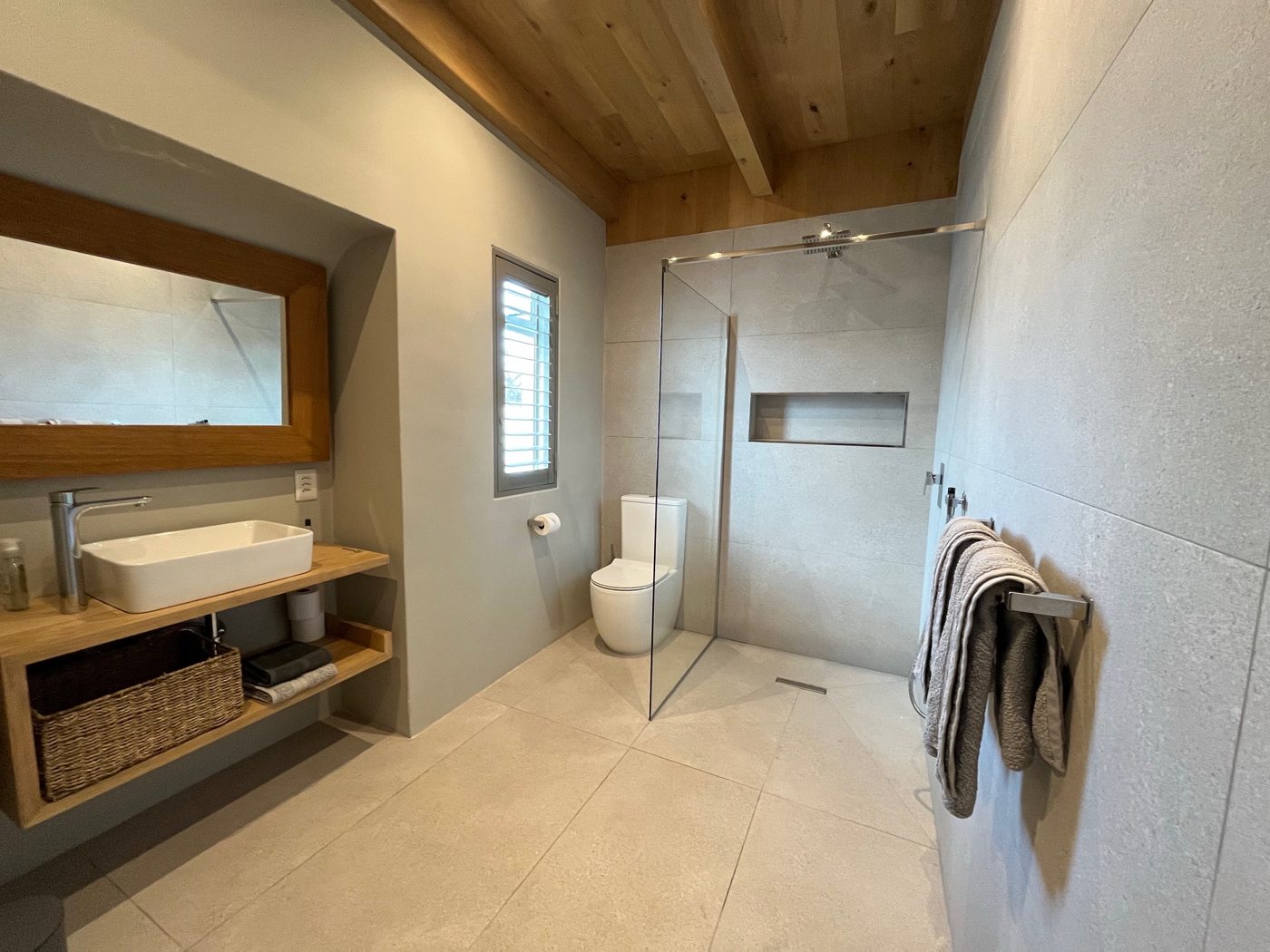 Modernes Badezimmer mit ebenerdiger Dusche, Holzwaschtisch und WC
