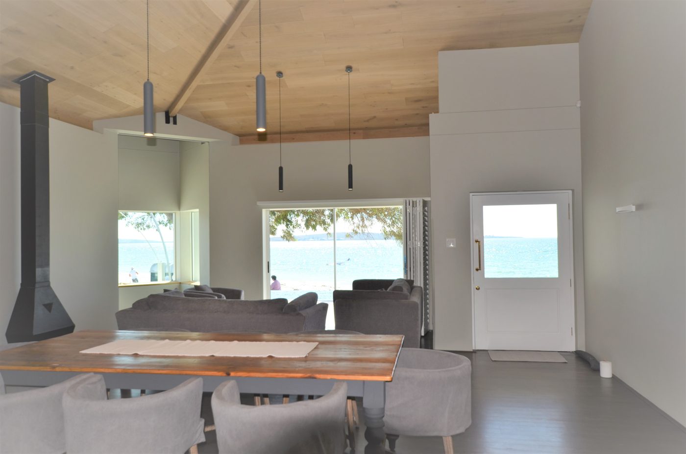 Essbereich mit grossem Holztisch und Blick aufs Meer
