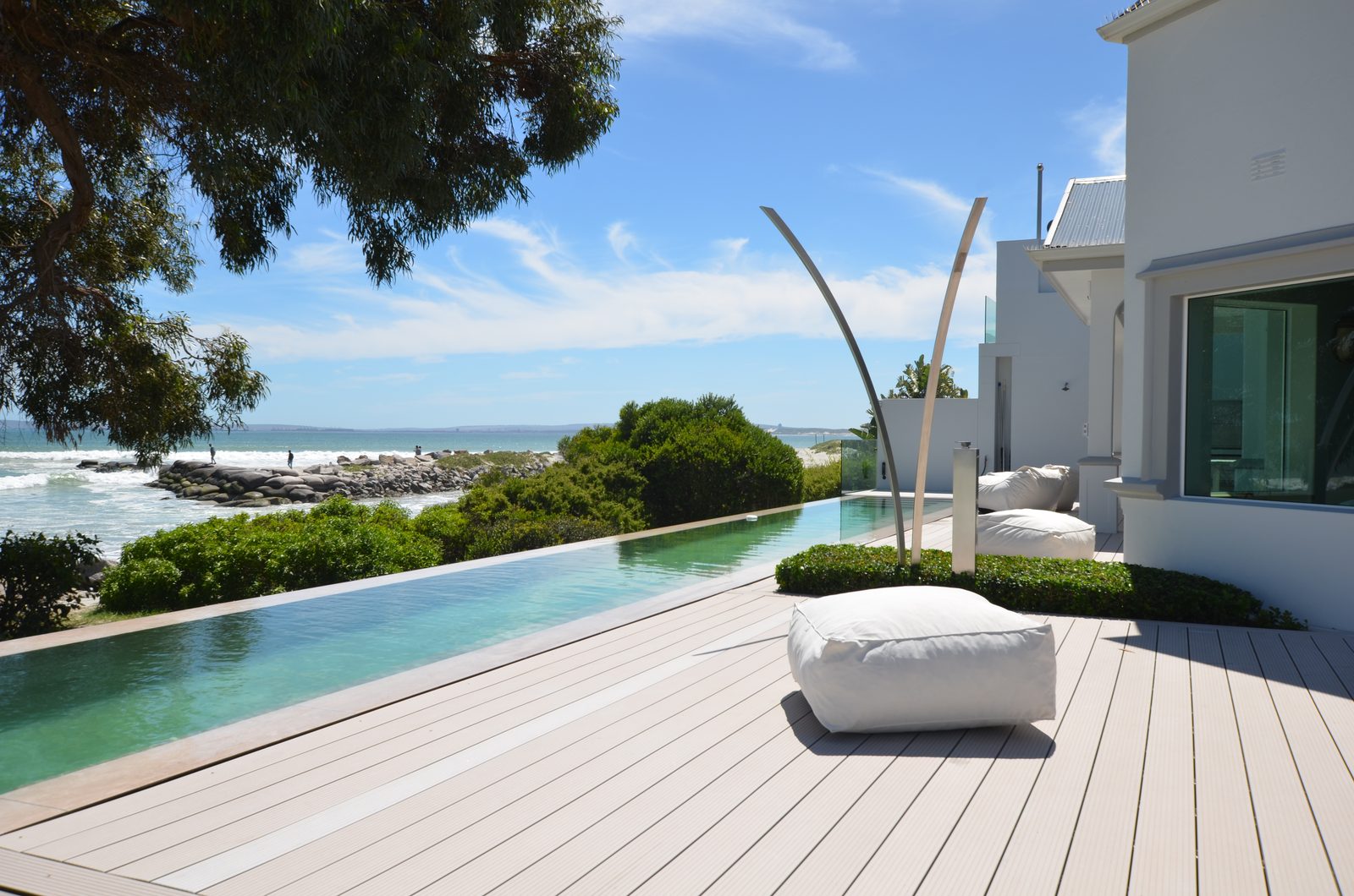 Langer Pool entlang der Terrasse vor dem Haus, mit Baum und Meerblick