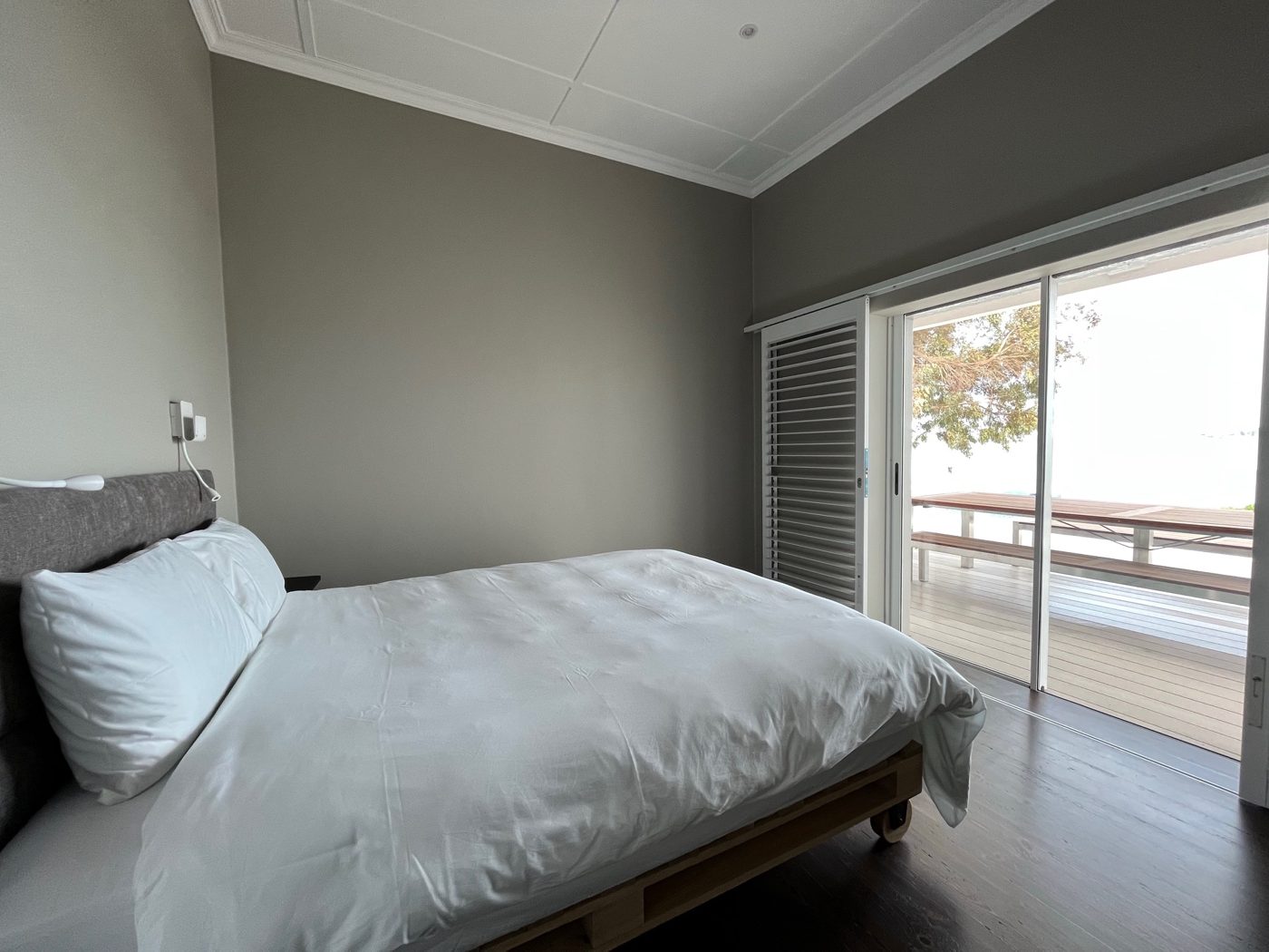 Schlafzimmer mit Doppelbett und Glastür zur Terrasse