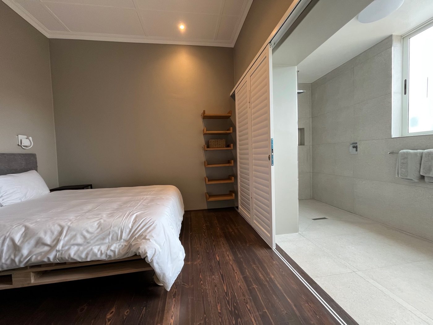 Schlafzimmer mit Doppelbett und offenem Bad