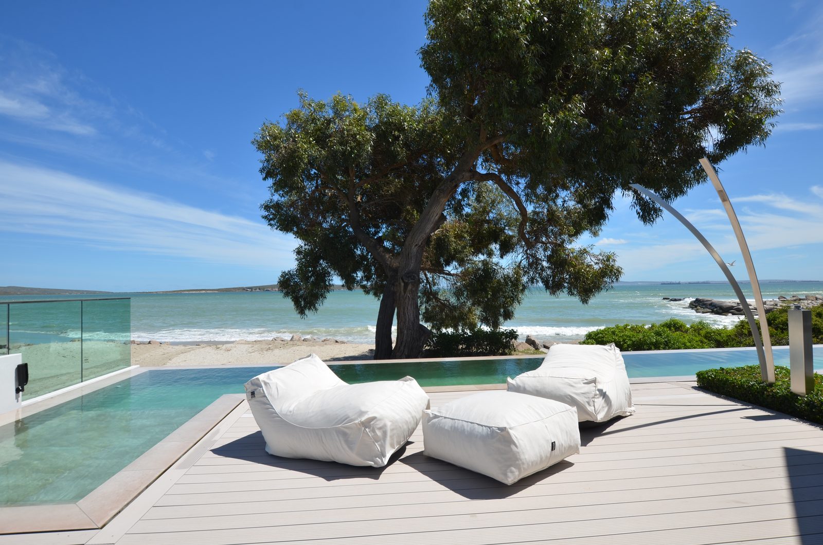 Terrasse am Infinity-Pool mit gemütlichen Sitzsäcken, Baum und Meerblick