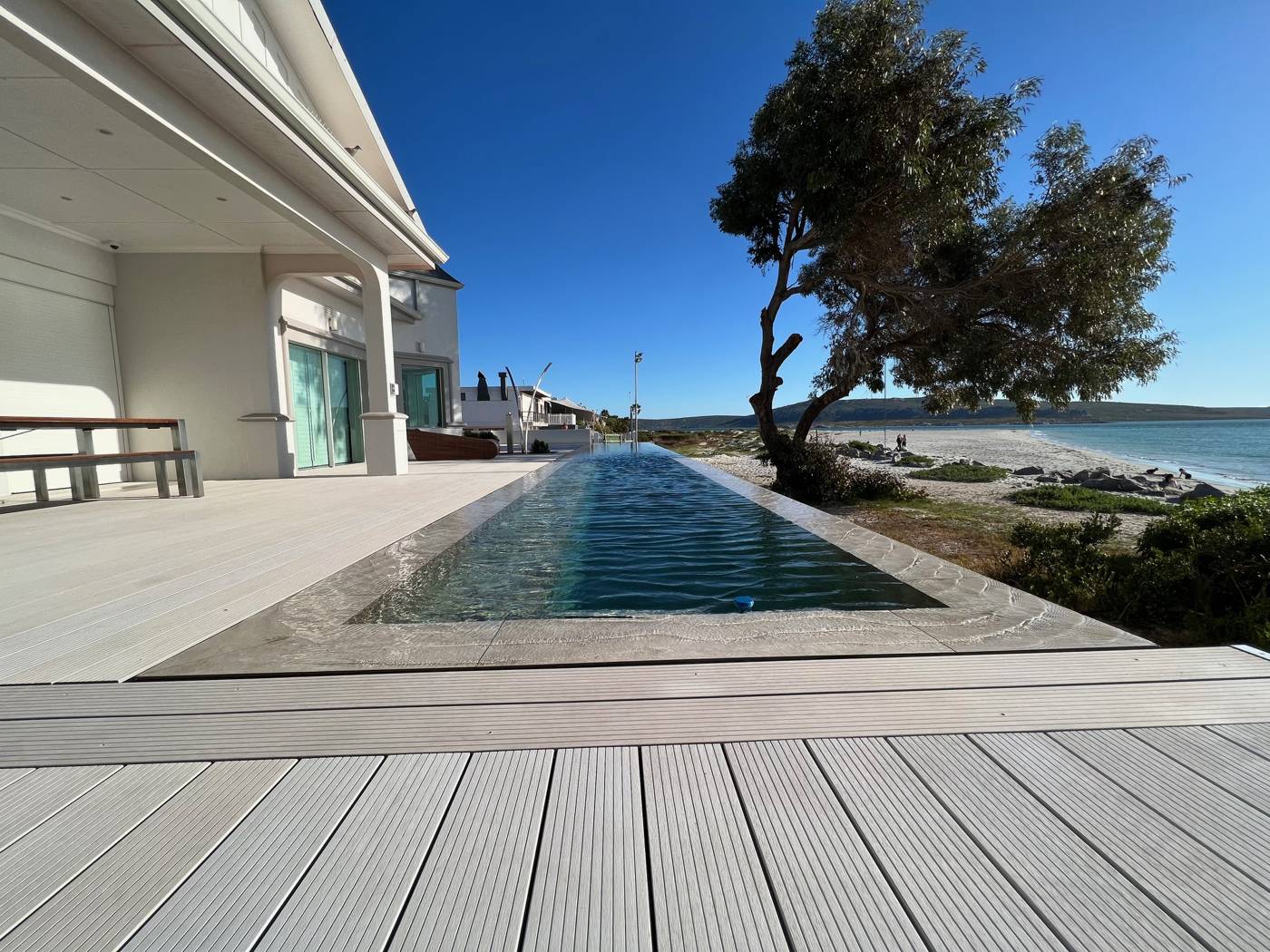 Langer Pool entlang der Holzterrasse vor dem Haus