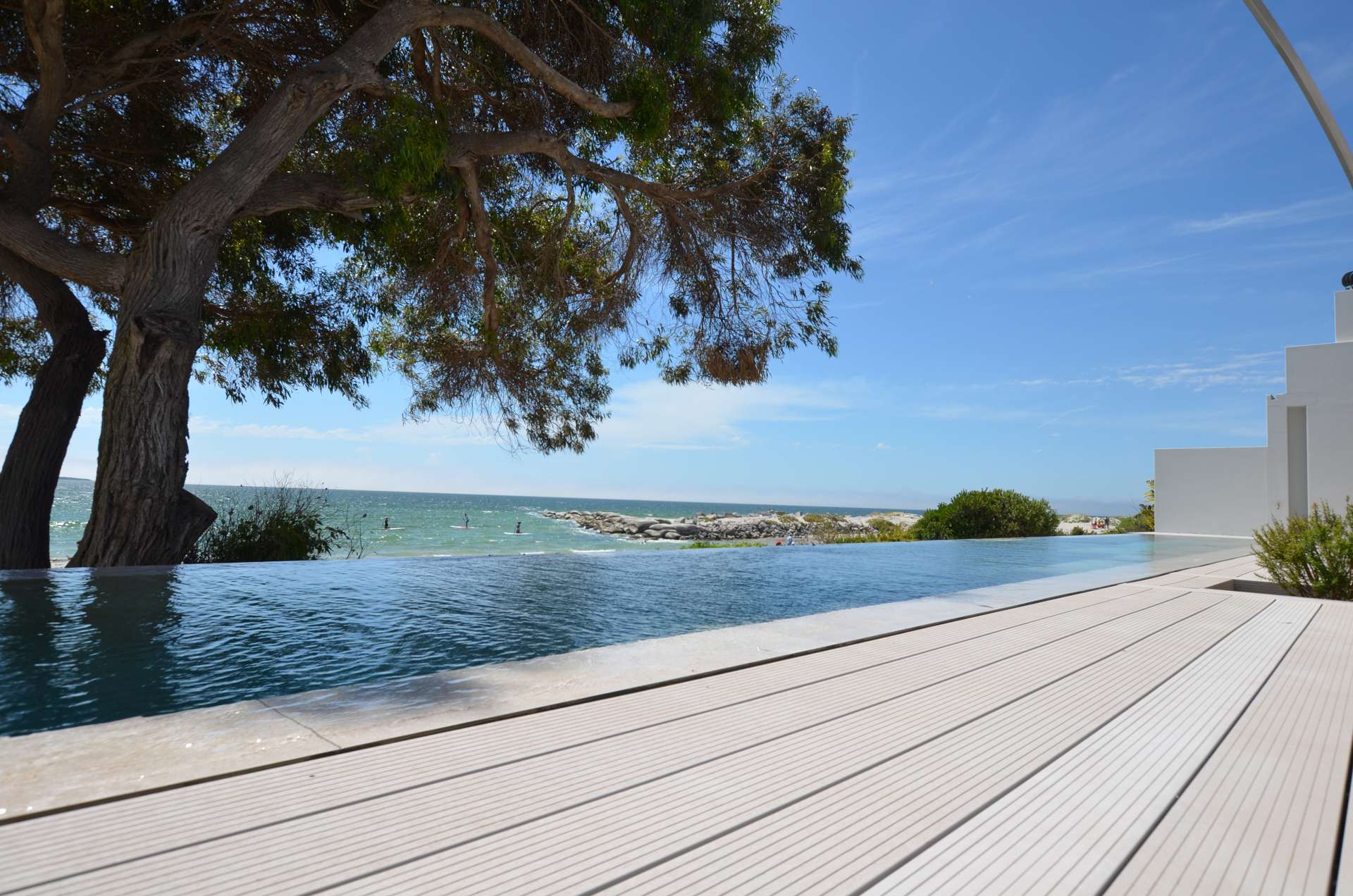 Infinity-Pool unter einem grossen Baum mit Blick aufs Meer